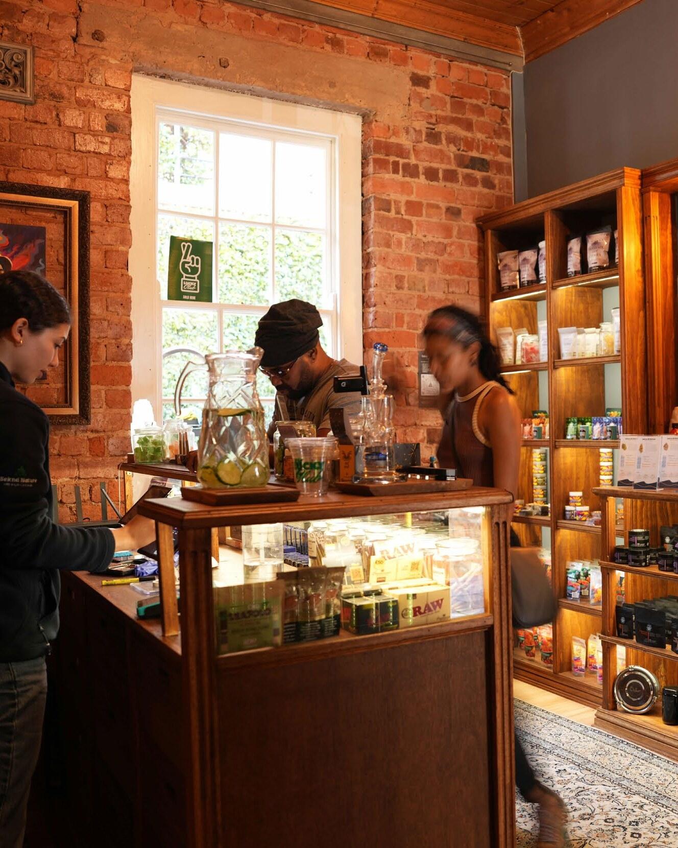 Inside the Seknd Nature shop — warm brick walls, wooden cabinets and members at the counter